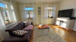 A living room with a sofa, a coffee table, a TV, and a cabinet.