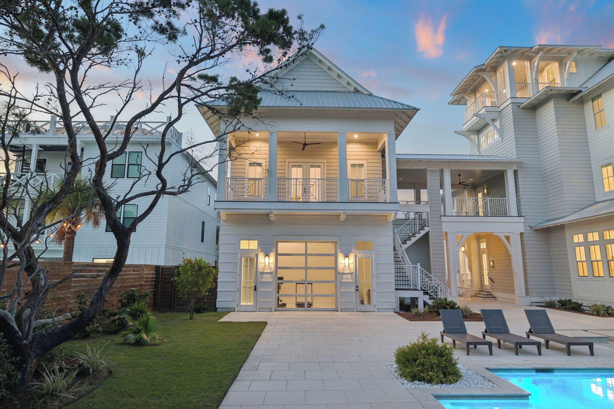 A two-story house with a large front porch, a swimming pool, and a well-maintained lawn.