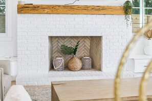 A white brick fireplace with a herringbone pattern, three woven baskets, and a single potted plant. - 30A White Dunes Retreat-Luxury Compound, Large Private Pool and Outdoor Space (Santa Rosa Beach)