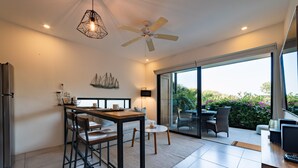 Une cuisine moderne avec un coin repas, un ventilateur de plafond et une vue sur l’extérieur.