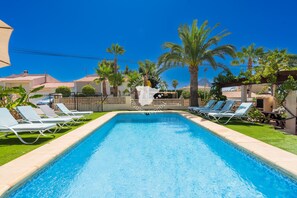 A rectangular pool with clear blue water, surrounded by white lounge chairs and palm trees. - CostaBlancaDreams - Casa Colibri in Calpe (Calpe)