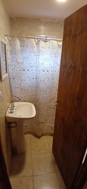 Een douche, een bidet, handdoeken, toiletpapier