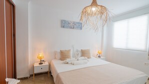 A bedroom with a bed, two bedside tables, a wall art piece, and a hanging light fixture. - CostaBlancaDreams - Pelicano / Frentemar in Calpe (Calpe)