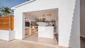 Una cucina moderna con pareti bianche, mobili in legno e un'isola centrale.