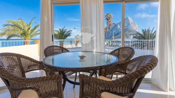 A round glass table with wicker chairs, a view of the sea, and a mountain in the background. - CostaBlancaDreams - Apartment Gran Sol in Calpe (Calpe / Calp)