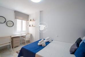 A bedroom with a bed, a desk, and a chair. There are two small potted plants on a shelf above the desk. - CostaBlancaDreams - Calpe Bay, Sonrisa in Calpe (Calpe / Calp)