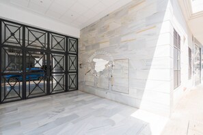 Experience a spacious, open area with a patterned floor and sleek glass doors, complemented by elegant walls and a decorative map.