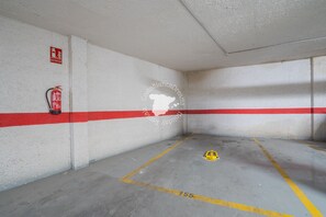 A parking garage with white walls, red and white stripes, and a fire extinguisher mounted on the wall. - CostaBlancaDreams - Calpe Bay, Sonrisa in Calpe (Calpe / Calp)