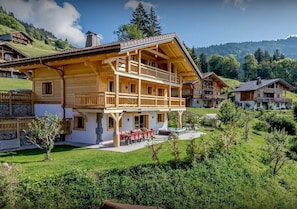A wooden chalet with a balcony, a pool, and a garden. - 14-person chalet ideal for families (Manigod)