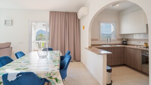 Eine moderne Küche mit Spüle, Herd und Essbereich mit Stühlen und Tisch.