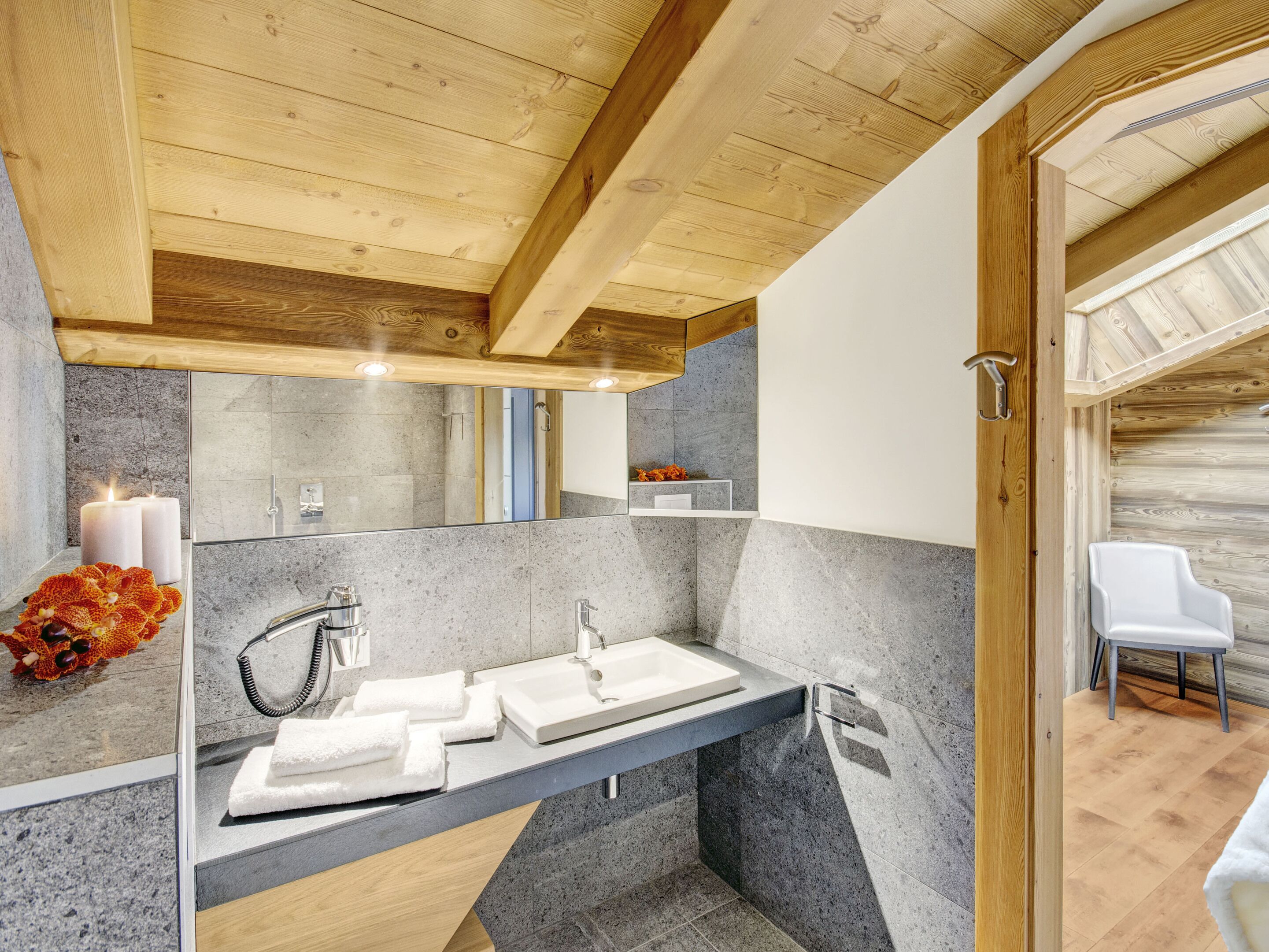 A modern bathroom with two sinks, a mirror, and a wooden ceiling.