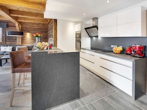 A modern kitchen with a central island, white cabinets, and a black countertop.