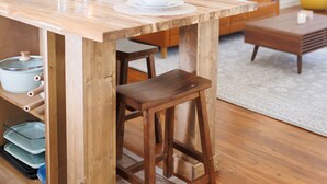 A wooden dining table with chairs, a sofa, and a coffee table in a living room. - Cozy Historic District Cottage (Dothan)