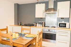 Comfort appartement | Privékeuken | Een koelkast met diepvriezer, een microgolfoven, een oven, een kookplaat