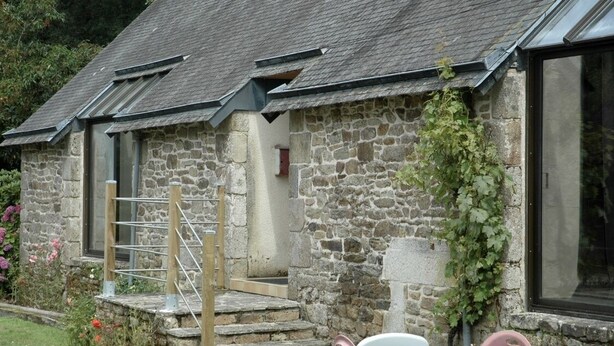 A stone building with a small porch and steps leading to a door. - Longère Bretonne sur Bord de Rivière (Arzano)