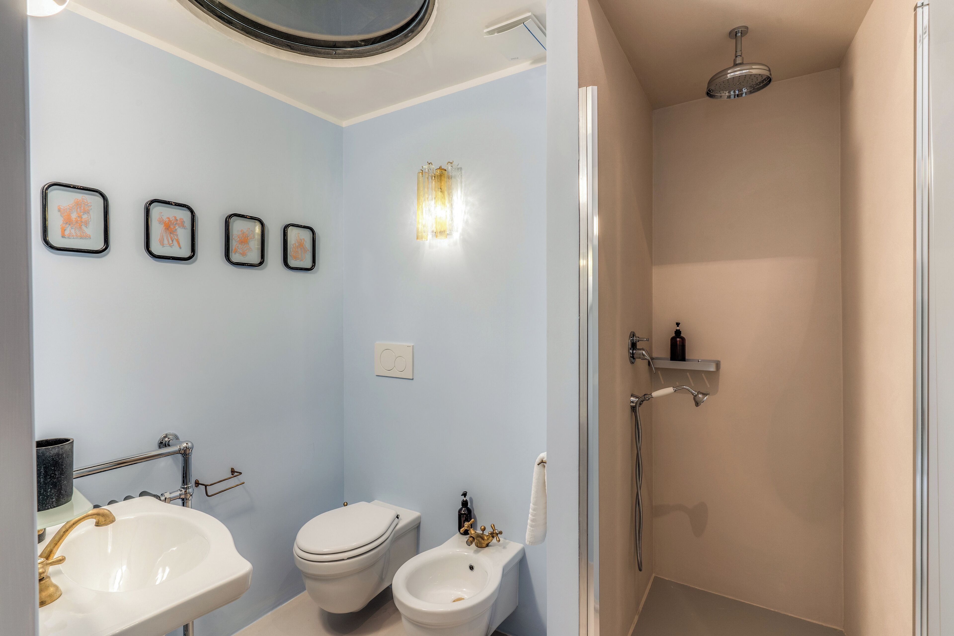 A bathroom with a sink, toilet, bidet, and shower.