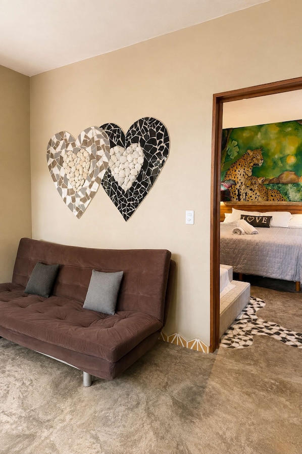 A living room with a brown sofa, two heart-shaped wall art pieces, and a painting of cheetahs on the wall.