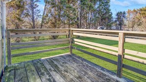 A wooden deck with a railing overlooking a grassy area with trees. - The Cozy Cottage of Florence!

 (Florence)