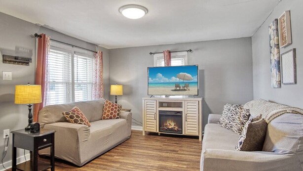 A living room with two sofas, a fireplace, a television, and a window with curtains. - The Cozy Cottage of Florence!

 (Florence)