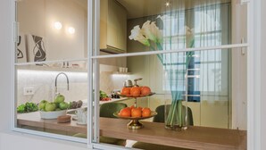 A kitchen with a wooden countertop, a fruit bowl, and a fruit stand. - The Victory Penthouse (Lucca)