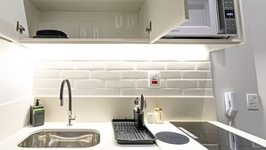 A modern kitchen with a stainless steel sink, a built-in oven, and a microwave. - chale leblon (Rio de Janeiro)