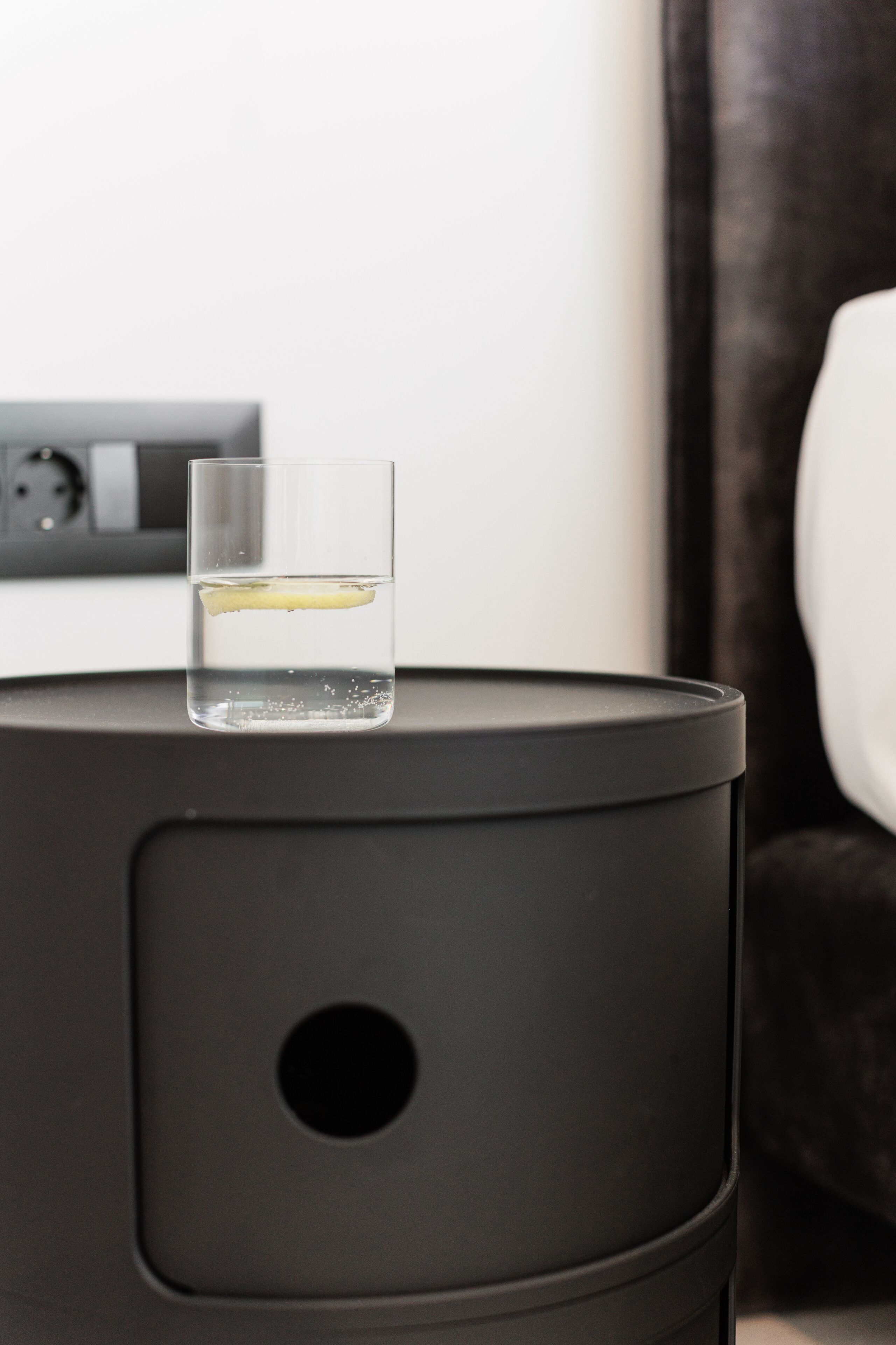 A black cylindrical object with a glass containing a yellow liquid on top.