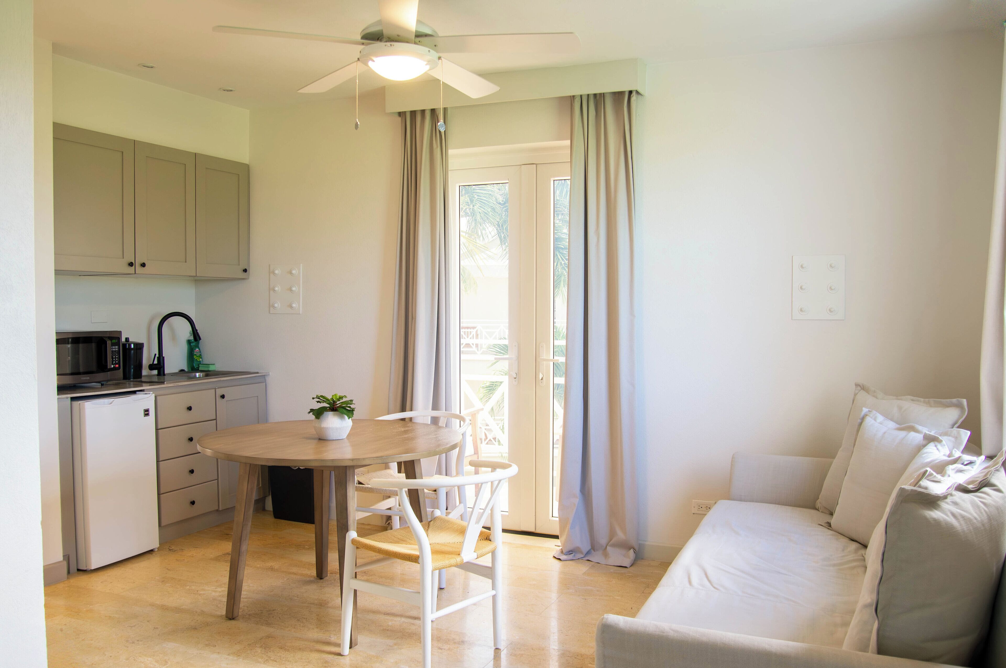 A compact living space with a kitchenette, a dining area, and a sofa.