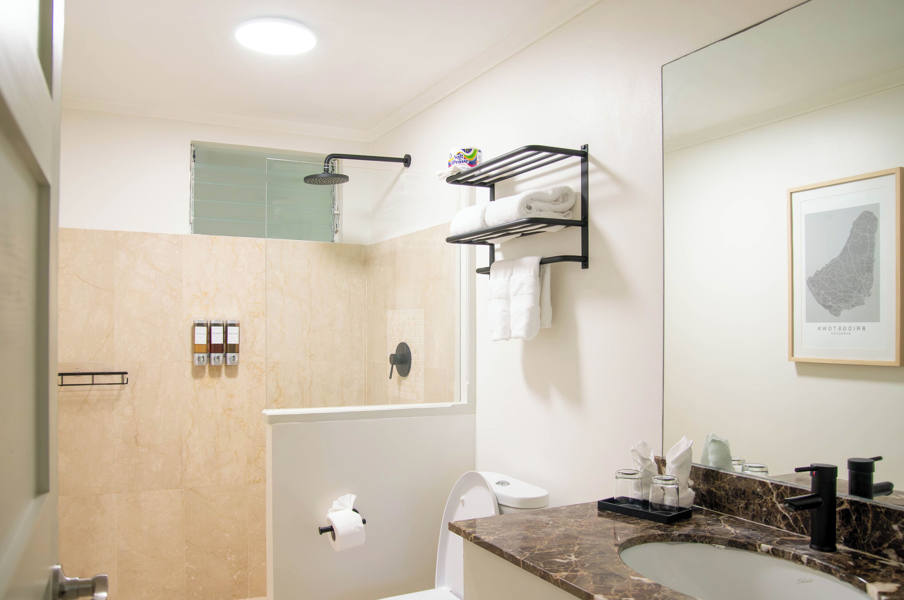 Een moderne badkamer met douche, toilet en wastafel.