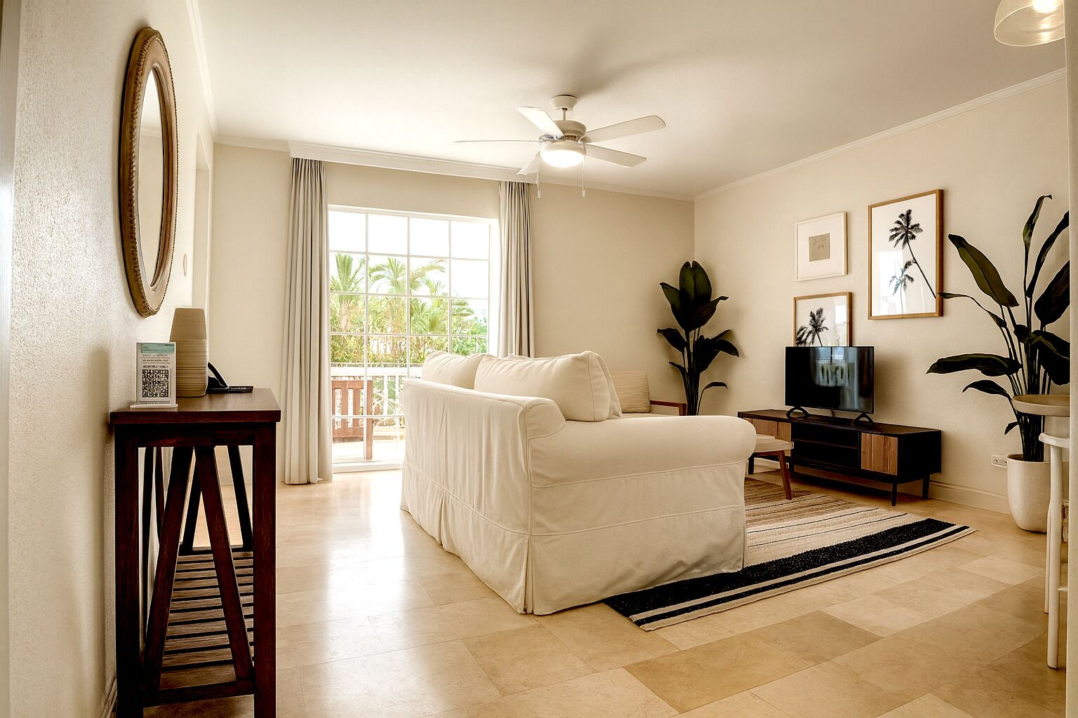 A living room with a sofa, TV, and a ceiling fan.