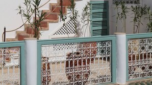 A white building with a staircase, green shutters, and potted plants. - Riad DAR DAR (Marrakech)