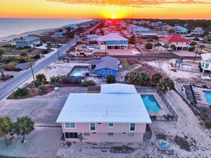 A coastal residential area with houses, a swimming pool, and a road. - TROUT Steps to beach. Lovely two bedroom with screened porch and pool. (St. George Island)