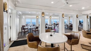 A spacious dining area with multiple tables and chairs, large windows offering views, and a modern ceiling design. - Sea Blue Escape | 30A 2BR | Pool + Walk to Beach (Santa Rosa Beach)