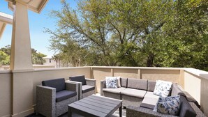 An outdoor patio with wicker furniture, including a sofa and chairs, and a table. - Sea Blue Escape | 30A 2BR | Pool + Walk to Beach (Santa Rosa Beach)