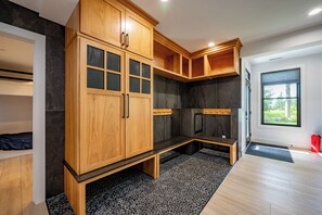 Un bagno moderno con mobili in legno, una panca e uno spazio doccia.