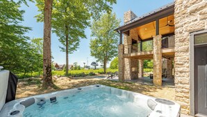 Ein Whirlpool mit Steinverkleidung und einer Holzterrasse.