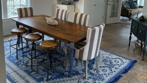A dining area with a wooden table, striped chairs, a blue patterned rug, and a hanging light fixture. - BEAUTIFUL LAKE HAMILTON COTTAGE - GREAT LOCATION, GREAT VIEWS - ADORABLE  3BD/3B (Hot Springs)