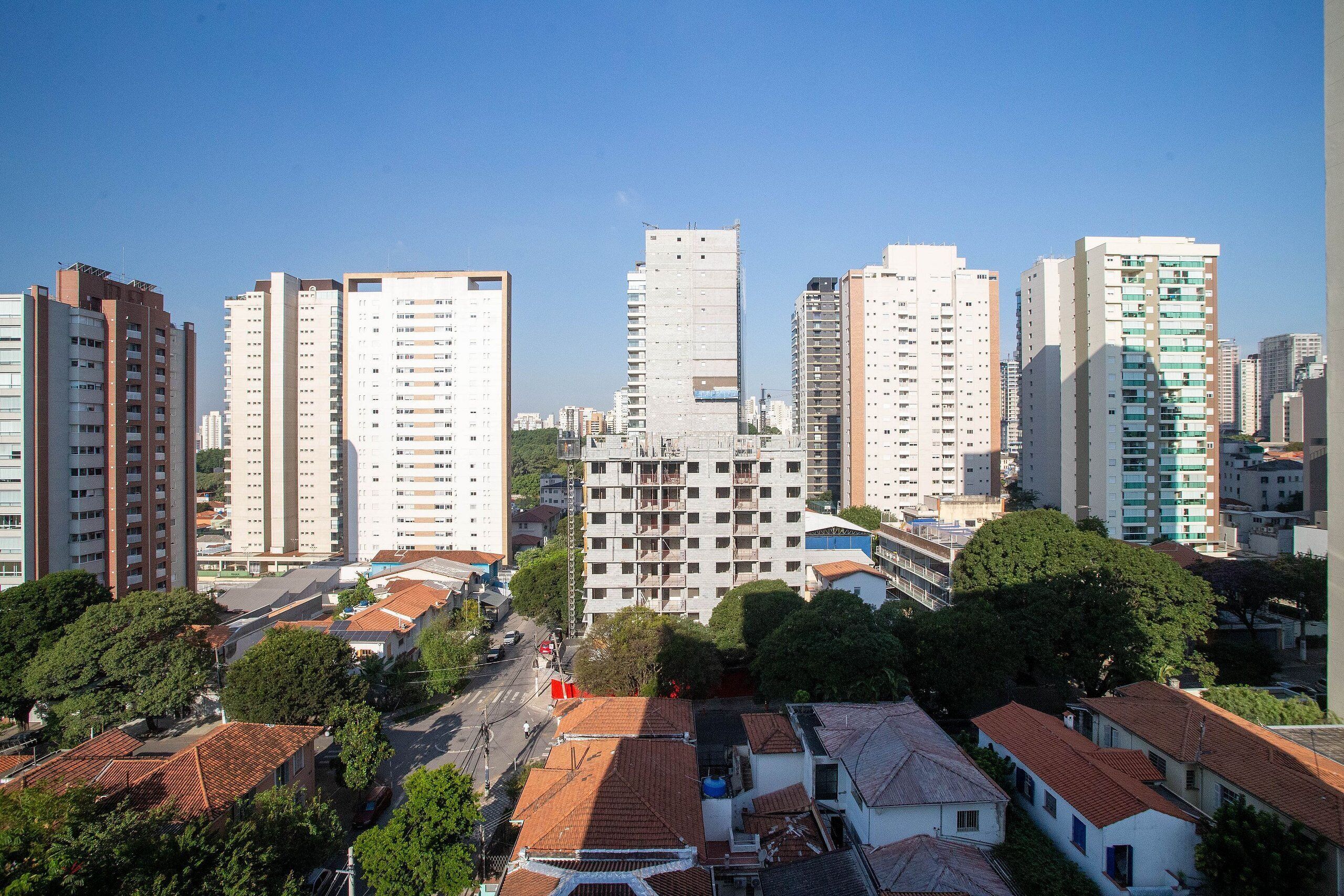 A cityscape with high-rise buildings, some with balconies, and a mix of residential and commercial structures.