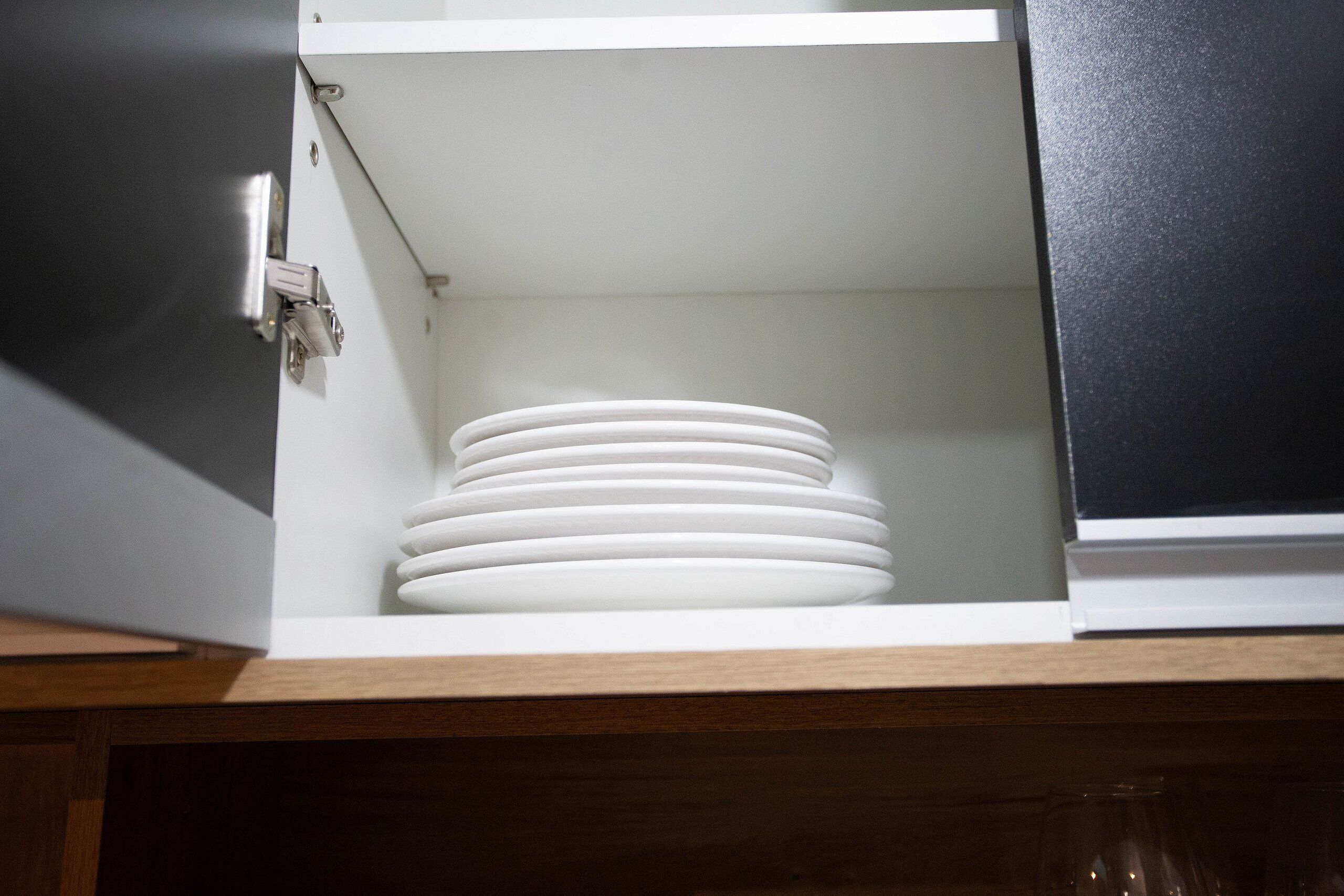 A kitchen cabinet with a white interior and a black exterior.