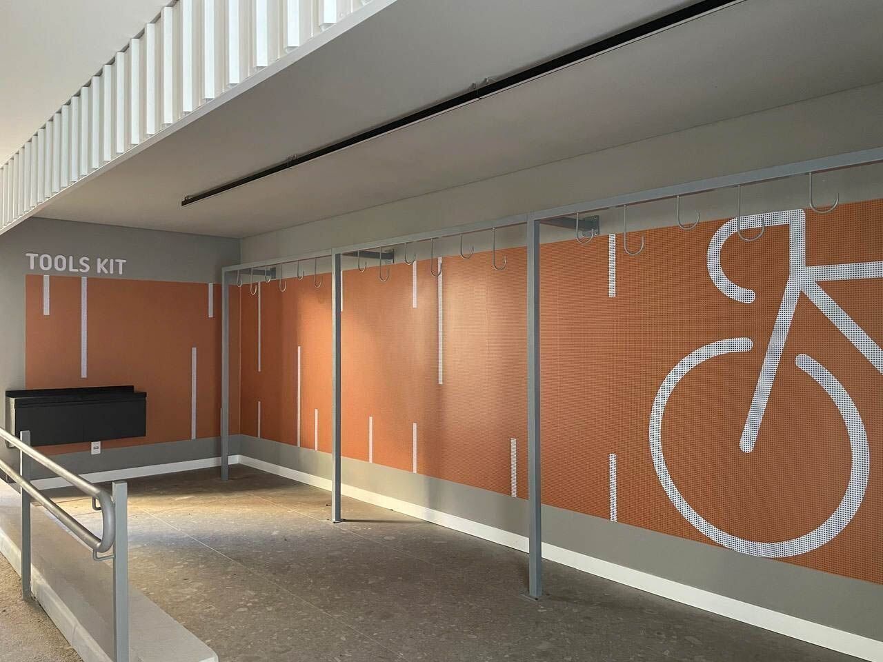 A modern indoor area with a tools kit and a large bicycle symbol on the wall.