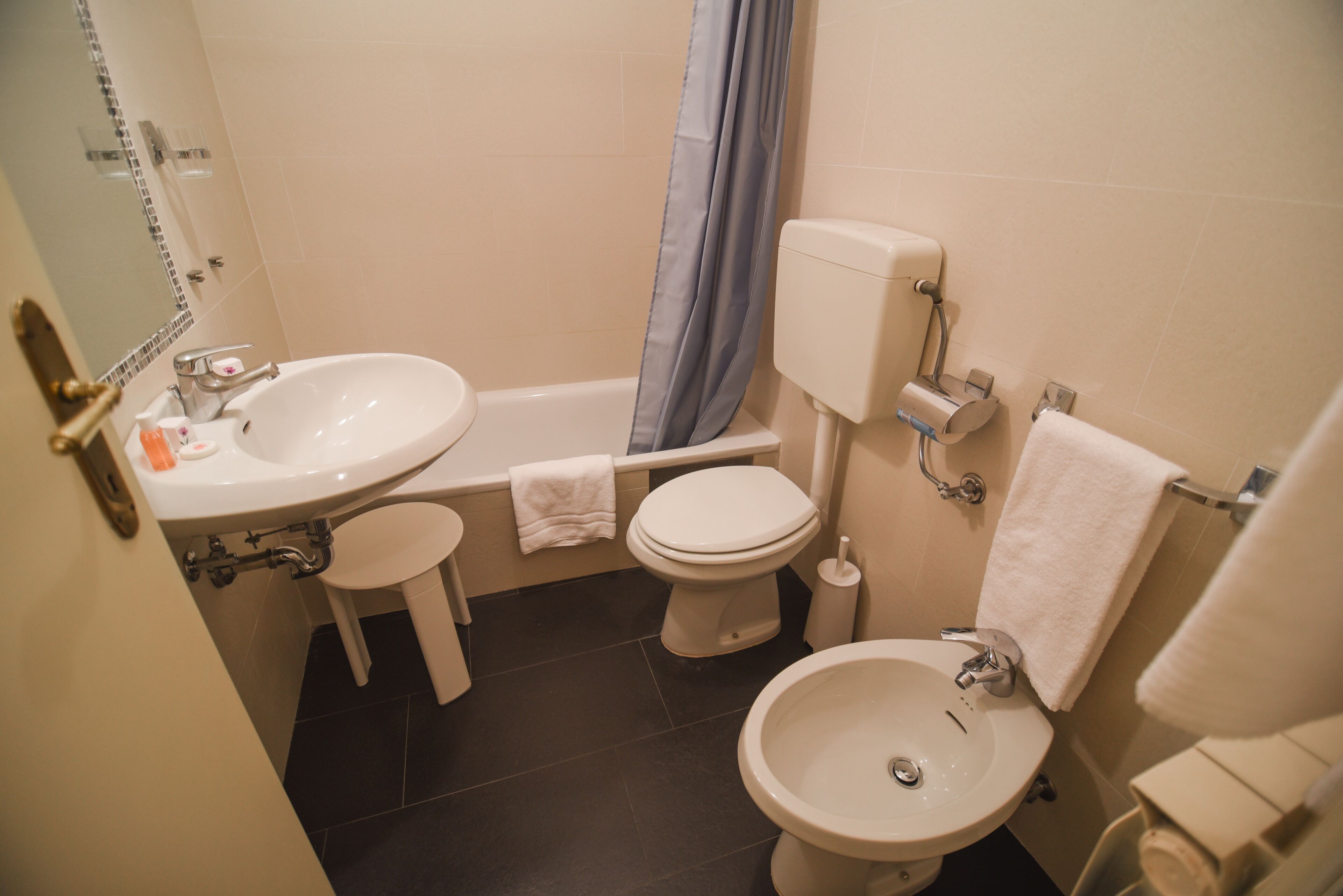 A bathroom with a sink, toilet, and bidet.