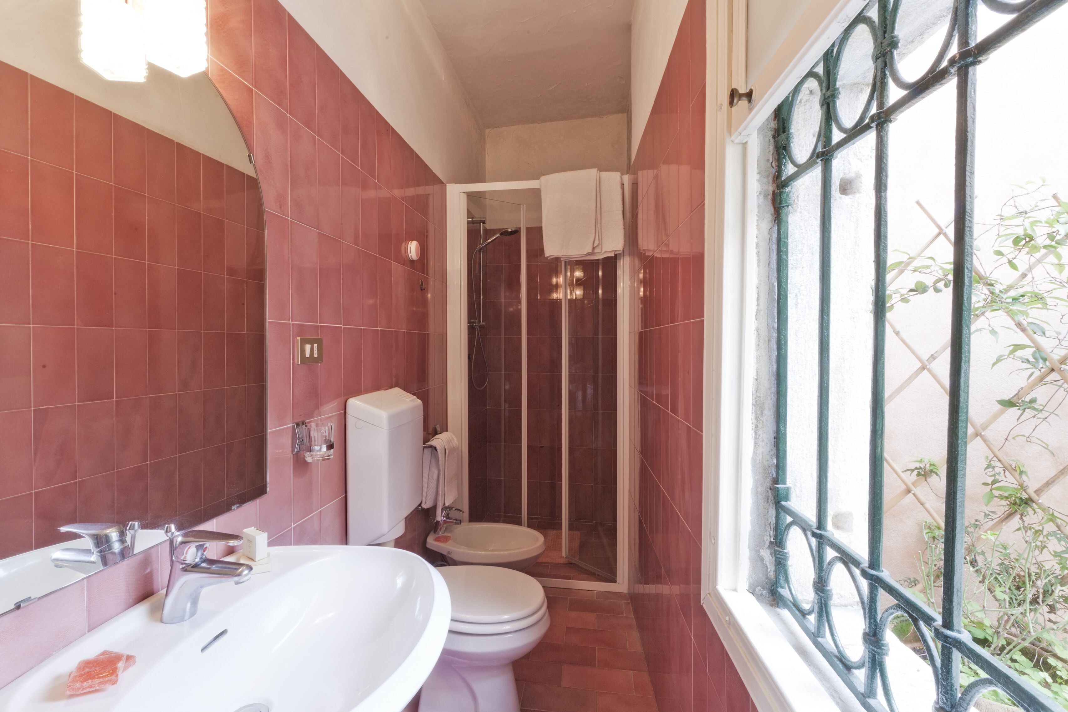 Un baño con un lavamanos blanco, un inodoro y una zona de ducha.