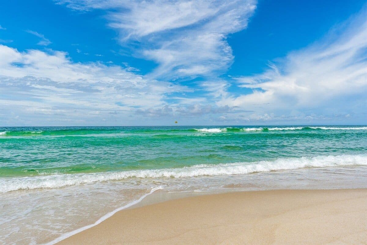 Ein Strand mit blauem Himmel und Wellen.