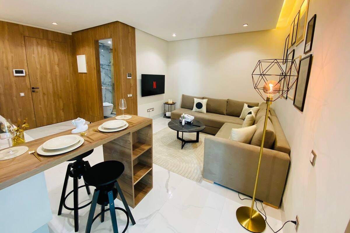 A modern living room with a sofa, coffee table, and a TV mounted on the wall.