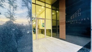 A modern building entrance with glass doors, a wooden floor, and a sign reading "ANFALORES". - Stay'Inn - Anfa Flores (Casablanca)