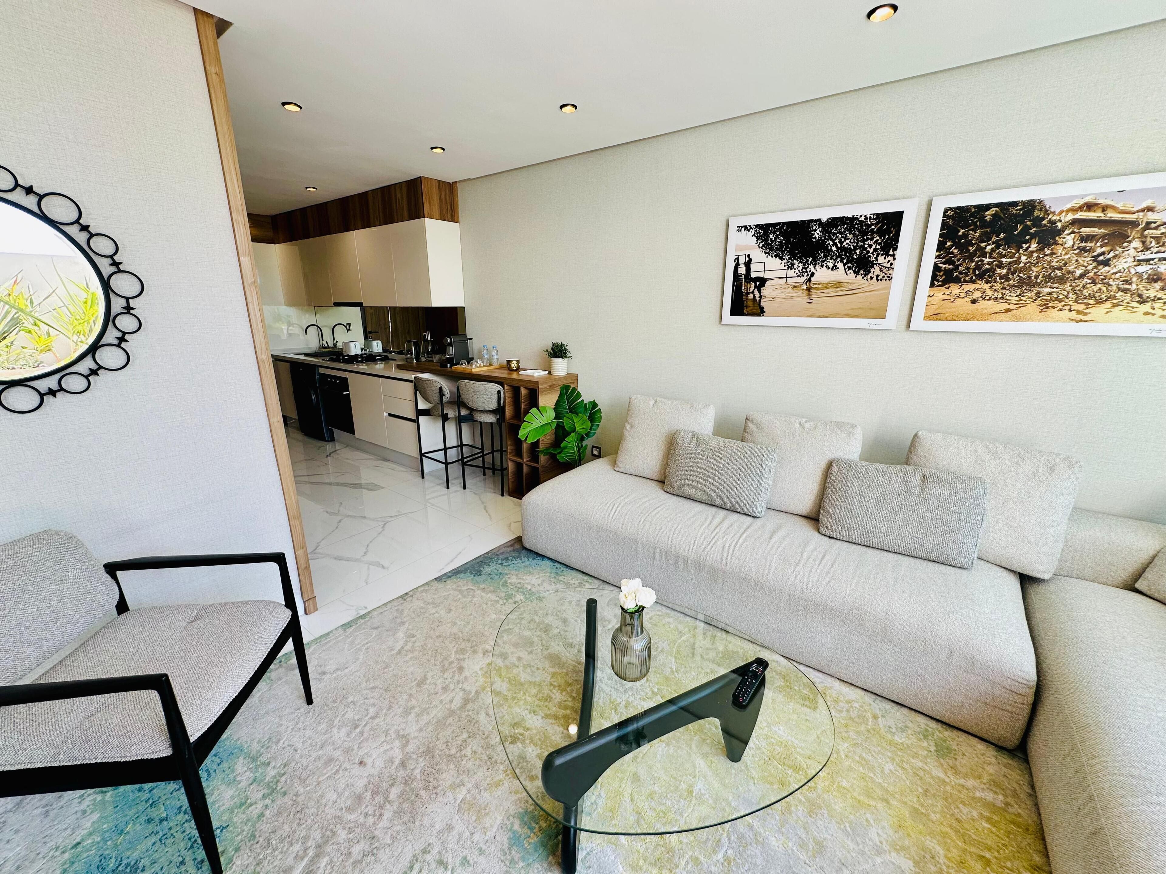 Una sala de estar moderna con un sofá, una mesa de centro y un comedor con una cocina al fondo.