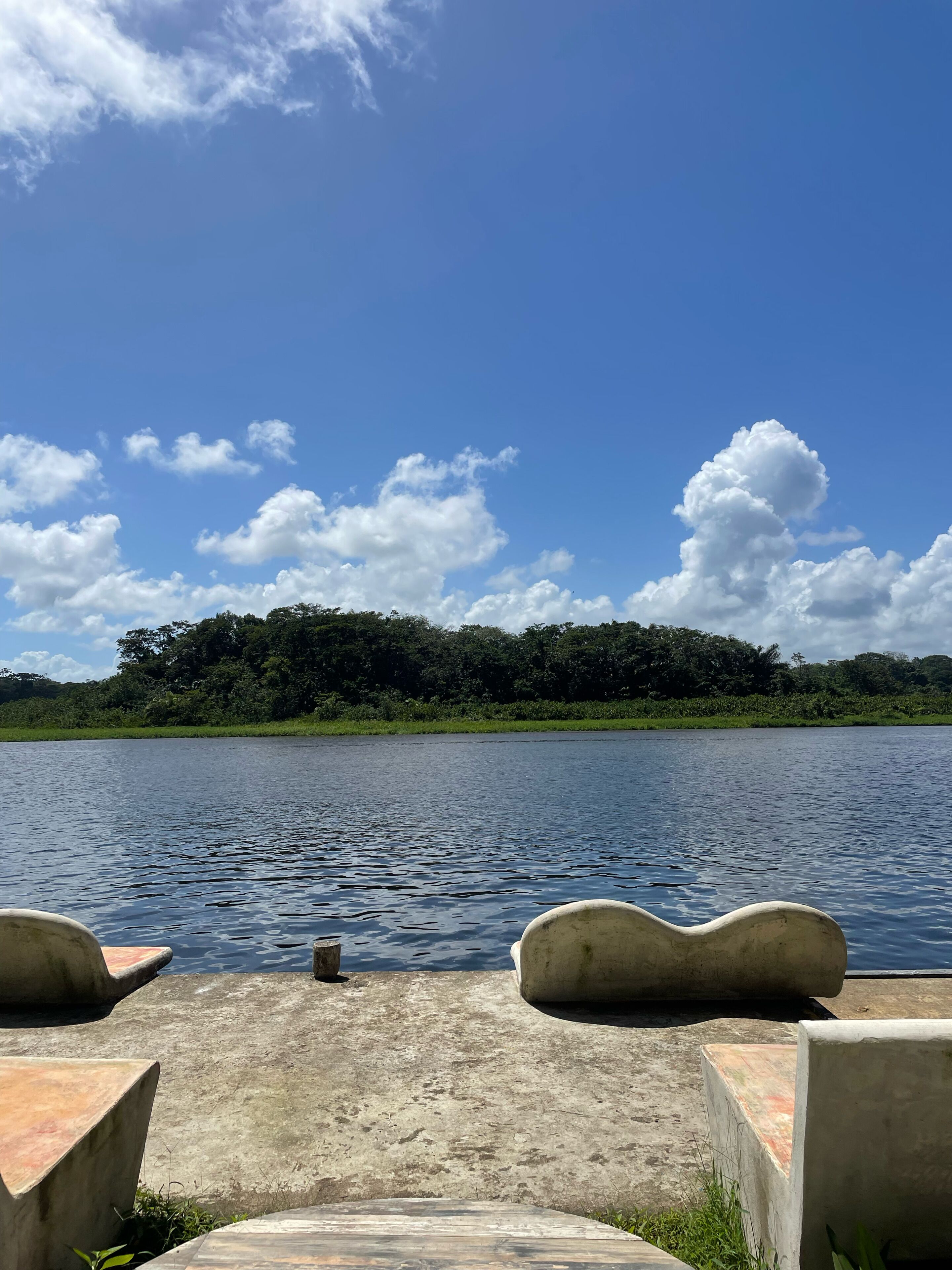 Una plataforma de hormigón con vistas a un lago y una colina boscosa.