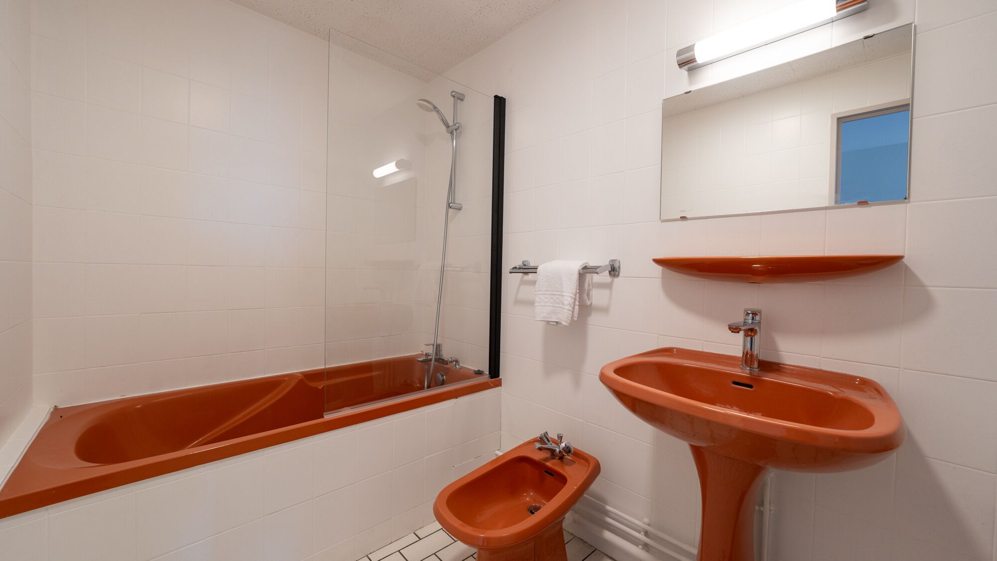 A bathroom with a bathtub, a bidet, and a sink.