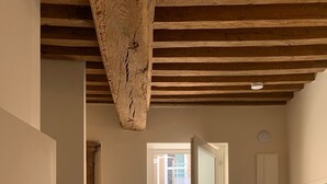 A modern kitchen with wooden beams, a dining table, and a view to the outside. - Hôtel des Docks (Digoin)