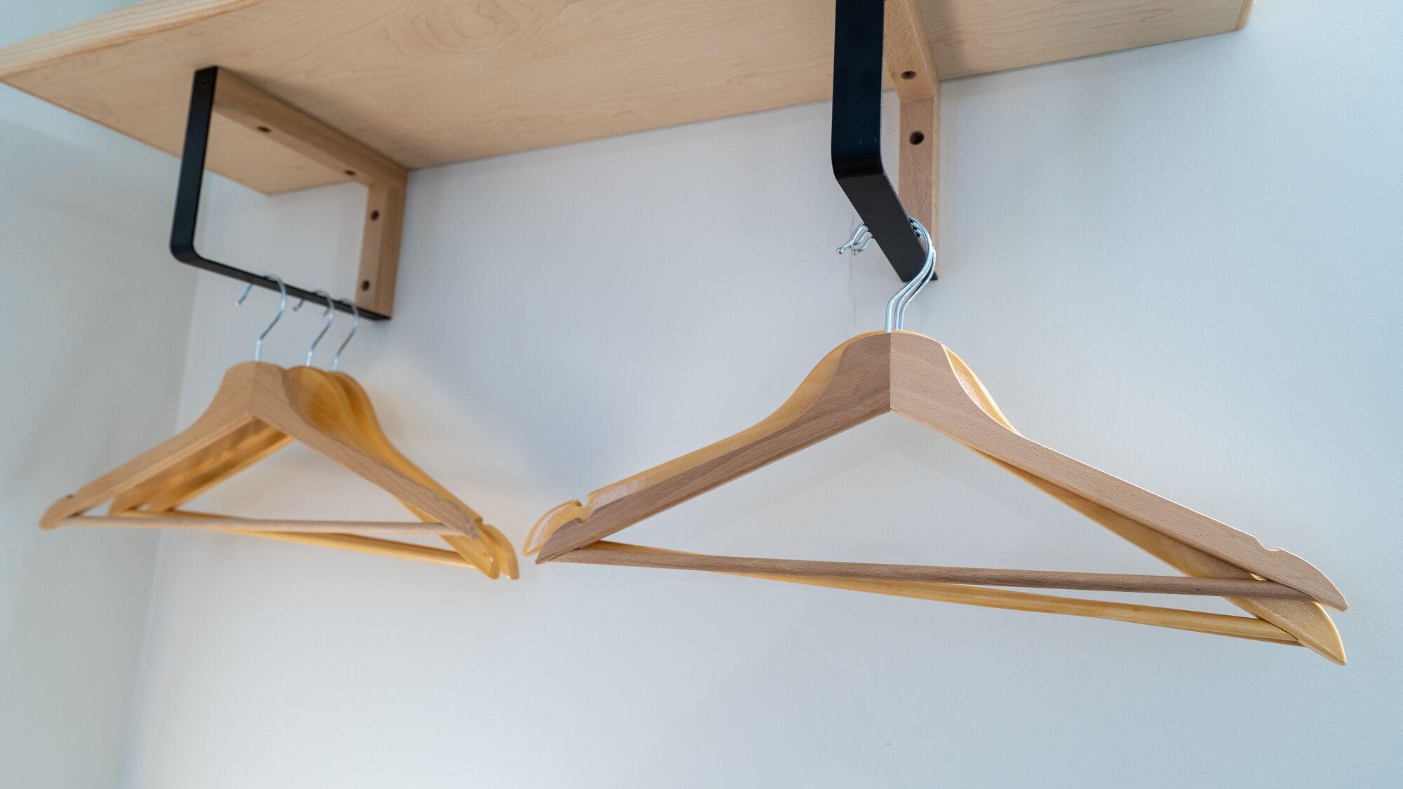 Twee houten kapstokhaken hangen aan het plafond.