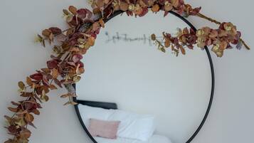 A circular mirror with a decorative arrangement of dried leaves and flowers.